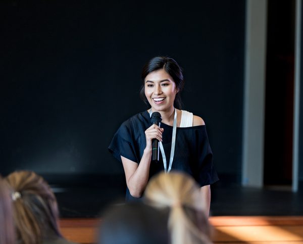 Young Hispanic woman gives a motivating speech during a conference or seminar.